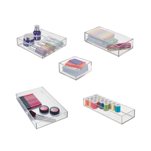 Transparent storage boxes with cosmetics, pens, yarn, and rubber bands in the room.