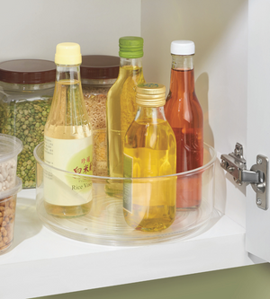 Der iDesign BINZ Drehteller Lazy Susan KLAR (23cm x 8,5cm) ist ein klarer, 360° drehbarer Organizer für Öl-, Essig- und Saucenflaschen im weißen Küchenschrank, ideal zur praktischen Vorratslagerung neben Gläsern mit Körnern und Bohnen.