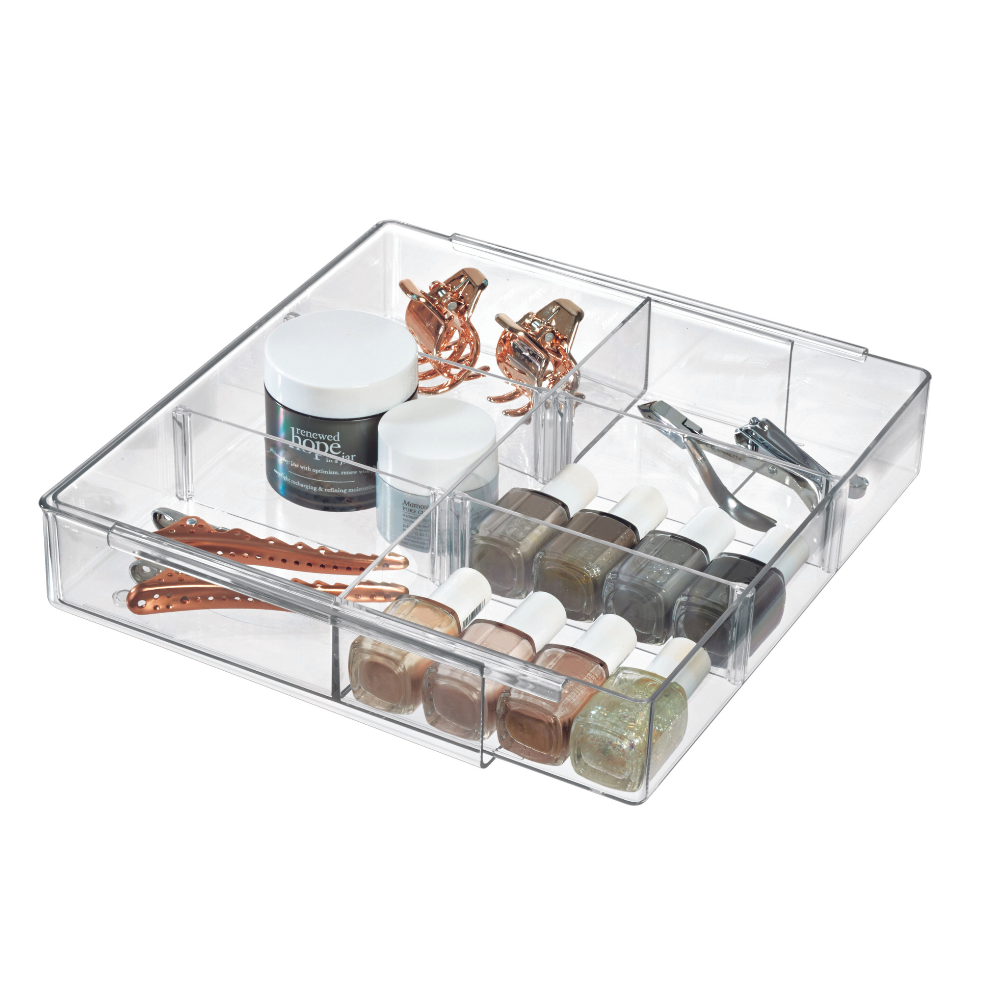 Der iDesign HOME EDIT - Schubladen Organizer KLAR - ausziehbar hält Nagellack, zwei Döschen, roségoldene Haarklammern, Nagelknipser und Haarnadeln ordentlich in separaten Fächern organisiert.