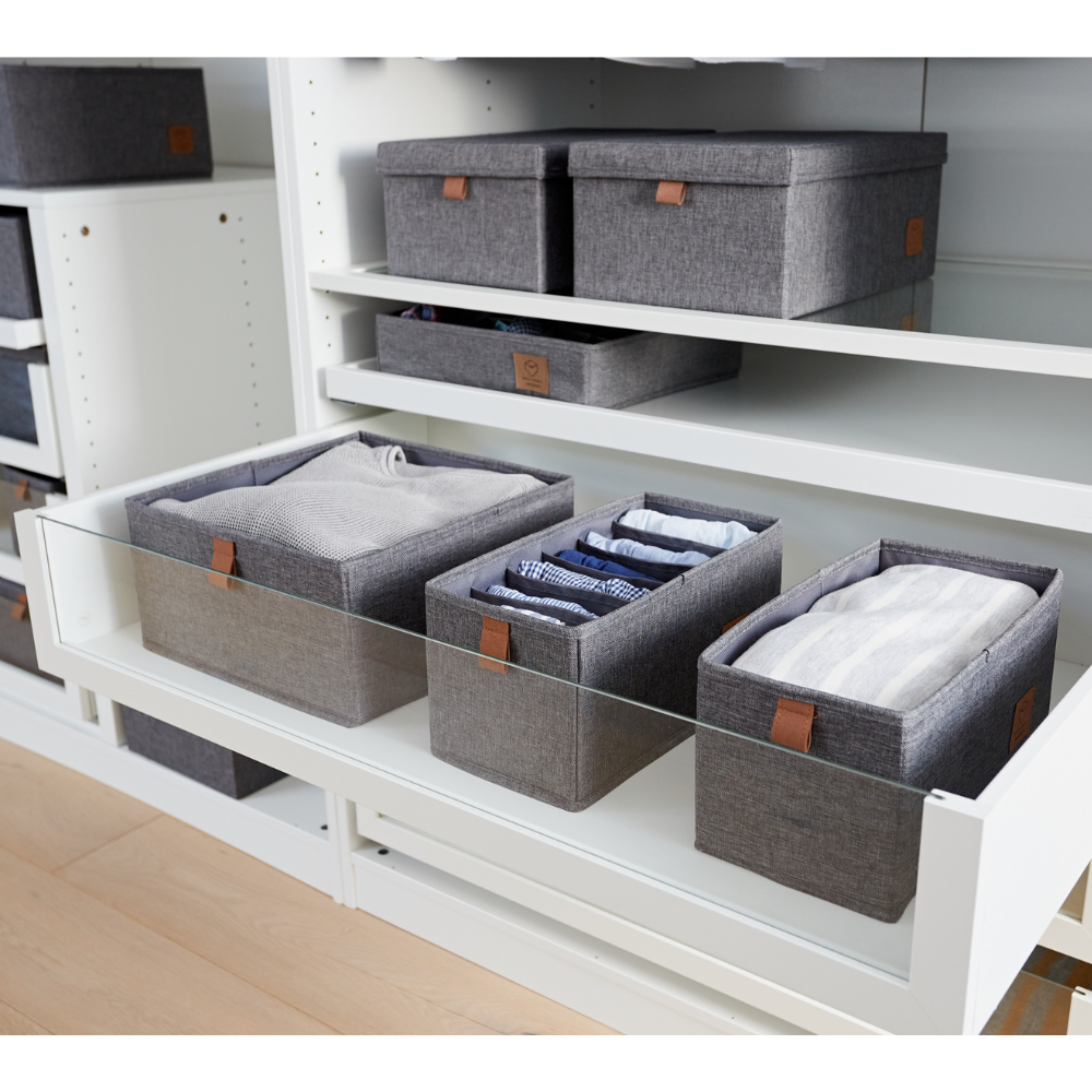 Zwei Love it Store it PREMIUM Organizer 6 Fächer schmal Grau sind auf einem weißen Regal mit Glaswänden in einem Kleiderschrank-Organizer angeordnet, jedes ordentlich mit Kleidung gefüllt. Weitere Aufbewahrungsfächer sind auf den Regalen darüber zu sehen.