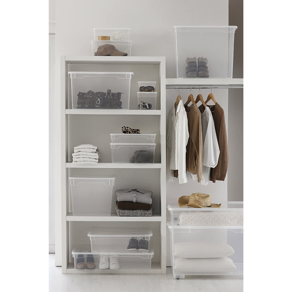 In einem gut organisierten Kleiderschrank stapelt die Rotho Aufbewahrungsbox CLEAR 2L (19x16,5x9cm) auf Regalen gefaltete Kleider, Schuhe, Taschen und Hüte; an einer Stange hängen neutrale Hemden und Jacken auf Holzbügeln.