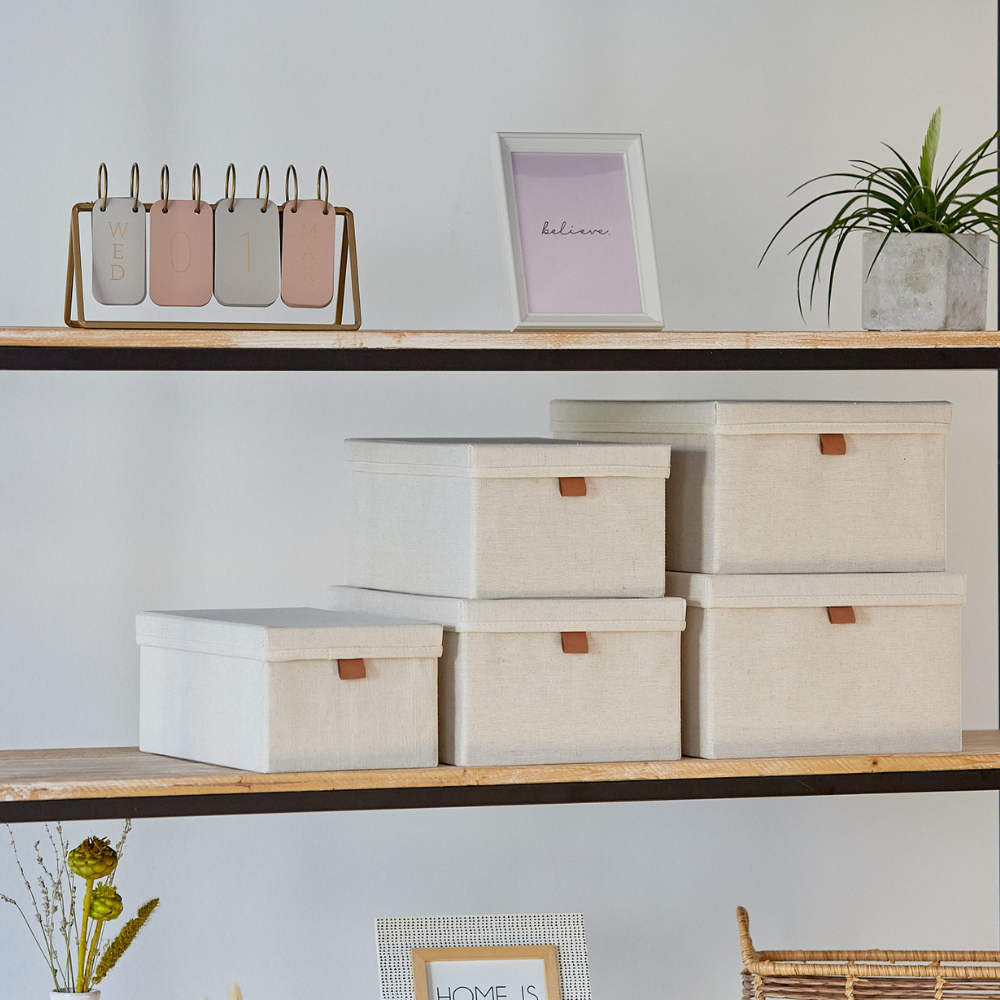 Ein Holzregal mit Love it Store it PREMIUM Aufbewahrungsboxen mit Deckel Beige (5er Set), verstärkte Kartonwände, "believe" gerahmter Print, Metallkalender auf Mittwoch, Topfpflanze und Trockenblumen-stilvolle Ordnung Zuhause.