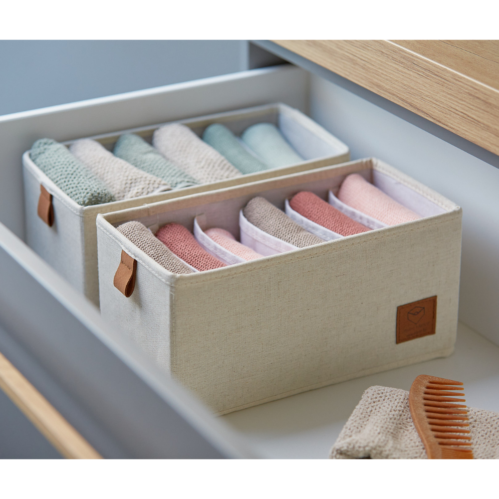 Zwei beige PREMIUM Organizer 6 Fächer schmal von Love it Store it sortieren pastellfarbene Waschlappen ordentlich in einer weißen Schublade. Mit braunen Griffen und einer Holzbürste in der Nähe, ist dieses 2-teilige Set sowohl stilvoll als auch praktisch für jeden Raum.