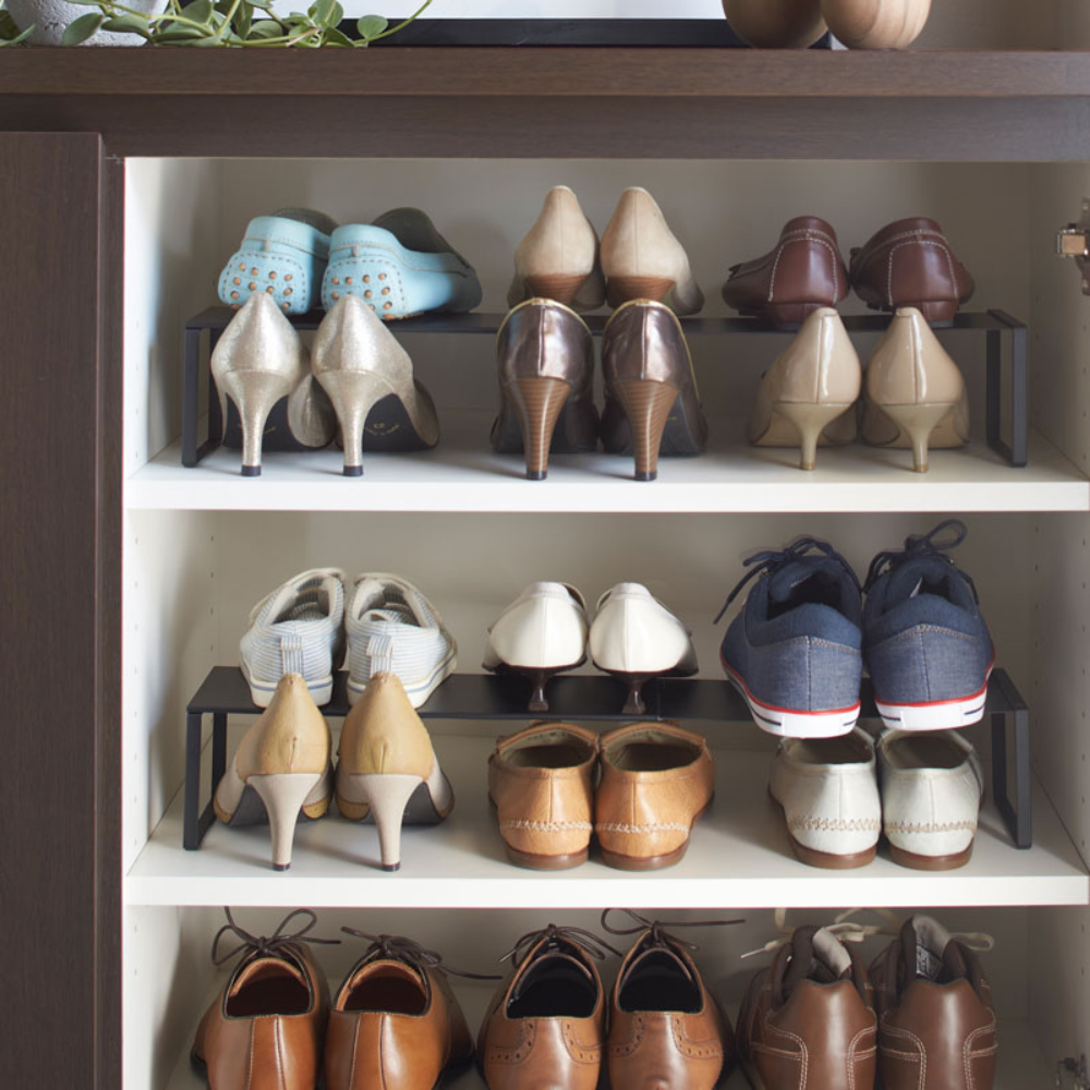 Das YAMAZAKI FRAME Schuhregal ausziehbar - Schwarz ordnet Damen- und Herrenschuhe, Sandalen und Sneakers auf drei Fächern in einem eleganten schwarzen Schrank für zusätzlichen Stauraum.