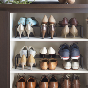 Das YAMAZAKI FRAME Schuhregal ausziehbar - Schwarz ordnet Damen- und Herrenschuhe, Sandalen und Sneakers auf drei Fächern in einem eleganten schwarzen Schrank für zusätzlichen Stauraum.