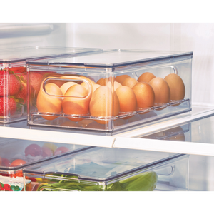 Transparente Box mit Eiern im Kühlschrank, daneben Erdbeeren und Gemüse.