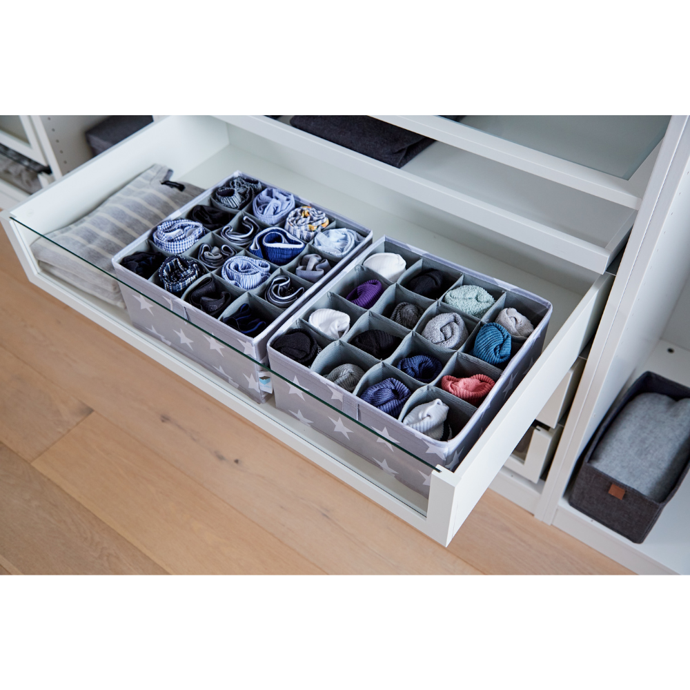 Ein weißes Regal fasst einen STAR Organizer 16 Fächer Grau - Set 2 Stk von Love it Store it, mit Stoffteilern, die Socken und Unterwäsche übersichtlich sortieren. Der Holzfußboden zeigt sich darunter - perfekt fürs Kinderzimmer.