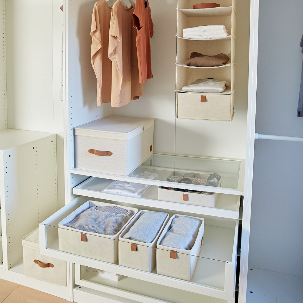 Ein ordentlich organisierter Kleiderschrank mit hängenden Hemden, gefalteter Kleidung in Love it Store it's PREMIUM Aufbewahrungsbox mit Klappdeckel - Beige, und Staufächern auf offenen Regalen und Glasschubladen, alles in einem minimalistischen Design mit neutralen Tönen.