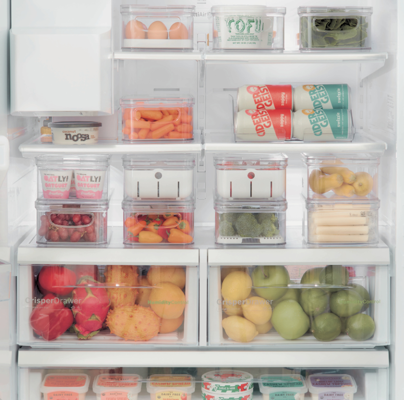 Kühlschrank mit Obst, Gemüse, Eiern und Getränken in transparenten Boxen.
