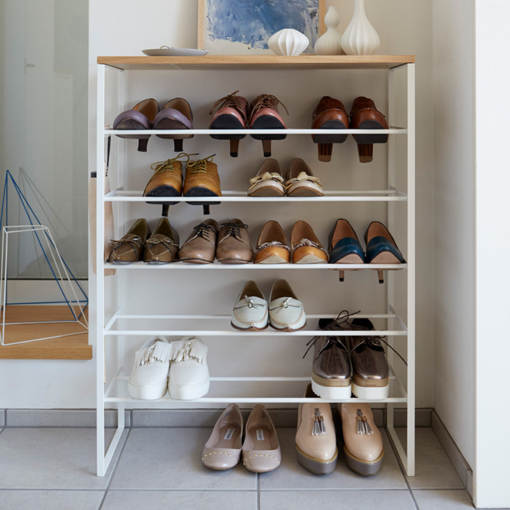 Der YAMAZAKI TOWER Schuhregal Holz in Weiss bietet fünf Ablagen für Damen-Schuhe wie Flats, Loafer und Oxfords in neutralen Farben. Das platzsparende Regal steht ordentlich im hellen Flur.