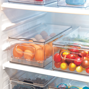 Kühlschrank mit Orangen, Tomaten und Beeren in Boxen.