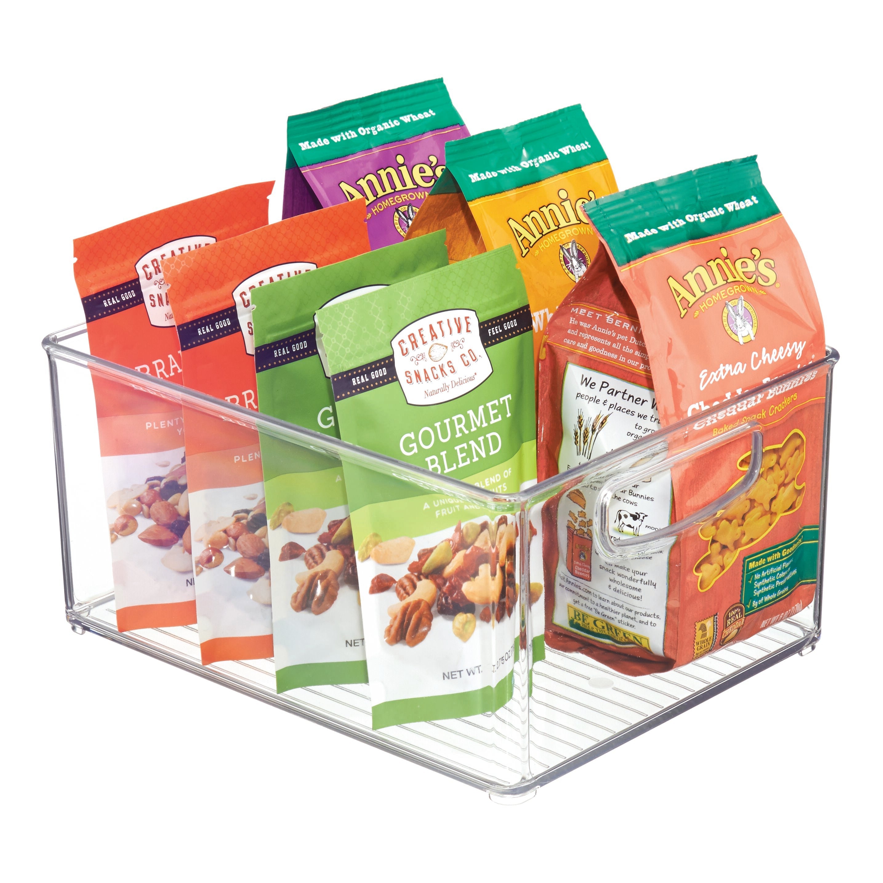 Contenitore trasparente con confezioni di snack "Creative Snacks Co." e "Annie's Homegrown".