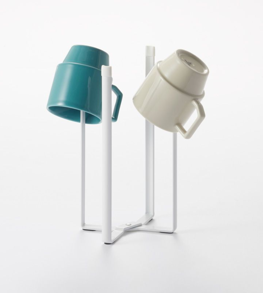 Zwei Keramikbecher, ein blaugrüner und ein beiger, stehen kopfüber auf einem YAMAZAKI TOWER Mehrzweckständer Küche - Weiss vor einem schlichten weißen Hintergrund.