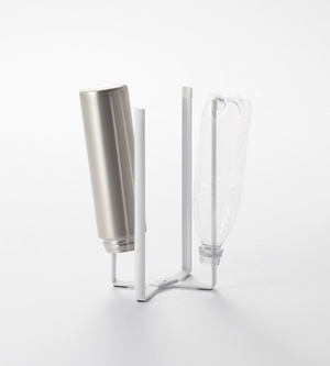 Auf dem YAMAZAKI TOWER Mehrzweckständer Küche - Weiss mit vier vertikalen Armen stehen eine Metallflasche und eine durchsichtige Plastikflasche auf dem Kopf, vor einem schlichten weißen Hintergrund.