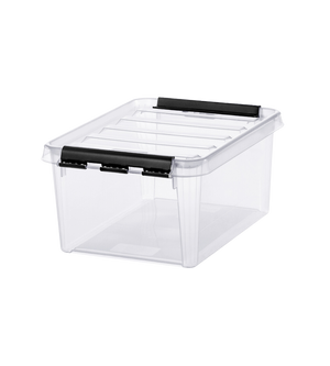Transparente Box mit schwarzem Clipverschluss liegt auf weißer Fläche.