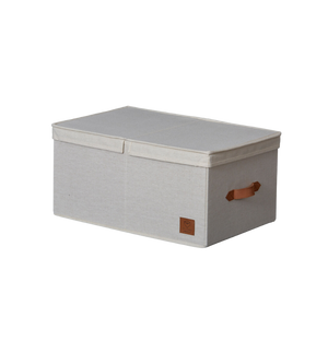 Die PREMIUM Aufbewahrungsbox mit Klappdeckel - Beige von Love it Store it ist eine rechteckige Aufbewahrungsbox mit aufgesetztem Deckel, braunem Seitengriff und Aufnäher auf der Vorderseite, abgebildet auf einem schlichten weißen Hintergrund.