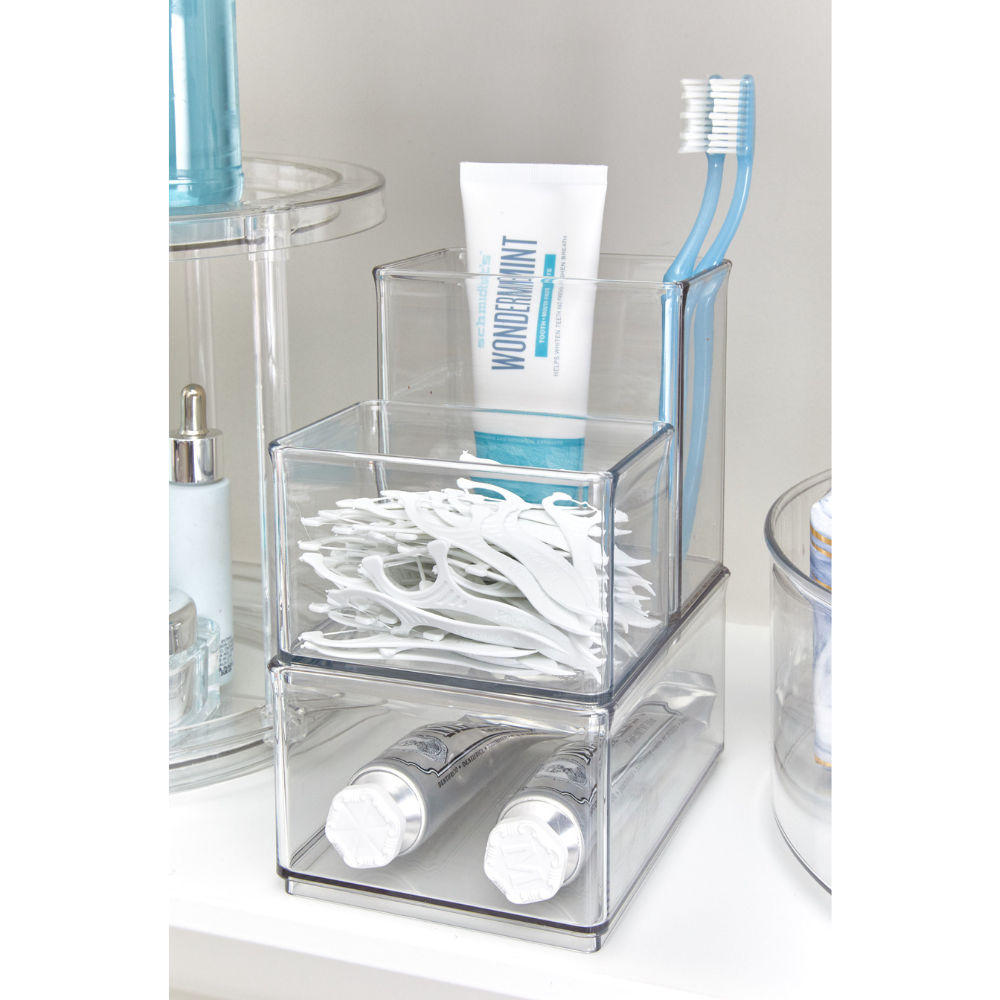 Sistema di conservazione con dentifricio, spazzolini da denti e filo interdentale in bagno, tubetto "WONDERMINT" in bella vista.