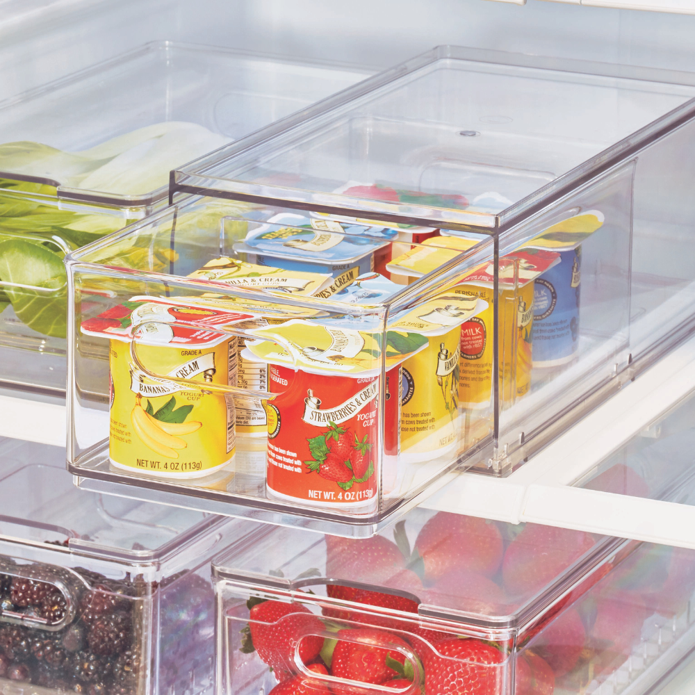 IDesign HOME EDIT - Aufbewahrungsbox Kühlschrank KLAR mit Schublade Schubladen sind mit Single-Serve-Joghurts in verschiedenen Geschmacksrichtungen gefüllt. Eine andere Schublade enthält Erdbeeren und Brombeeren, während im Hintergrund der obersten Schublade grüne Äpfel zu sehen sind.
