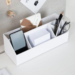 Weiße Schreibtisch-Organizerbox hält Handy, Stifte und Notizblöcke auf Schreibtisch.