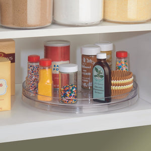 Der transparente iDesign LINUS Drehteller Lazy Susan KLAR (28cm x 4,5cm) sorgt mit 360°-Drehfunktion für Ordnung von Sprinkles, Backextrakten und Cupcake-Förmchen im Vorratsregal zwischen Gläsern und Schachteln.